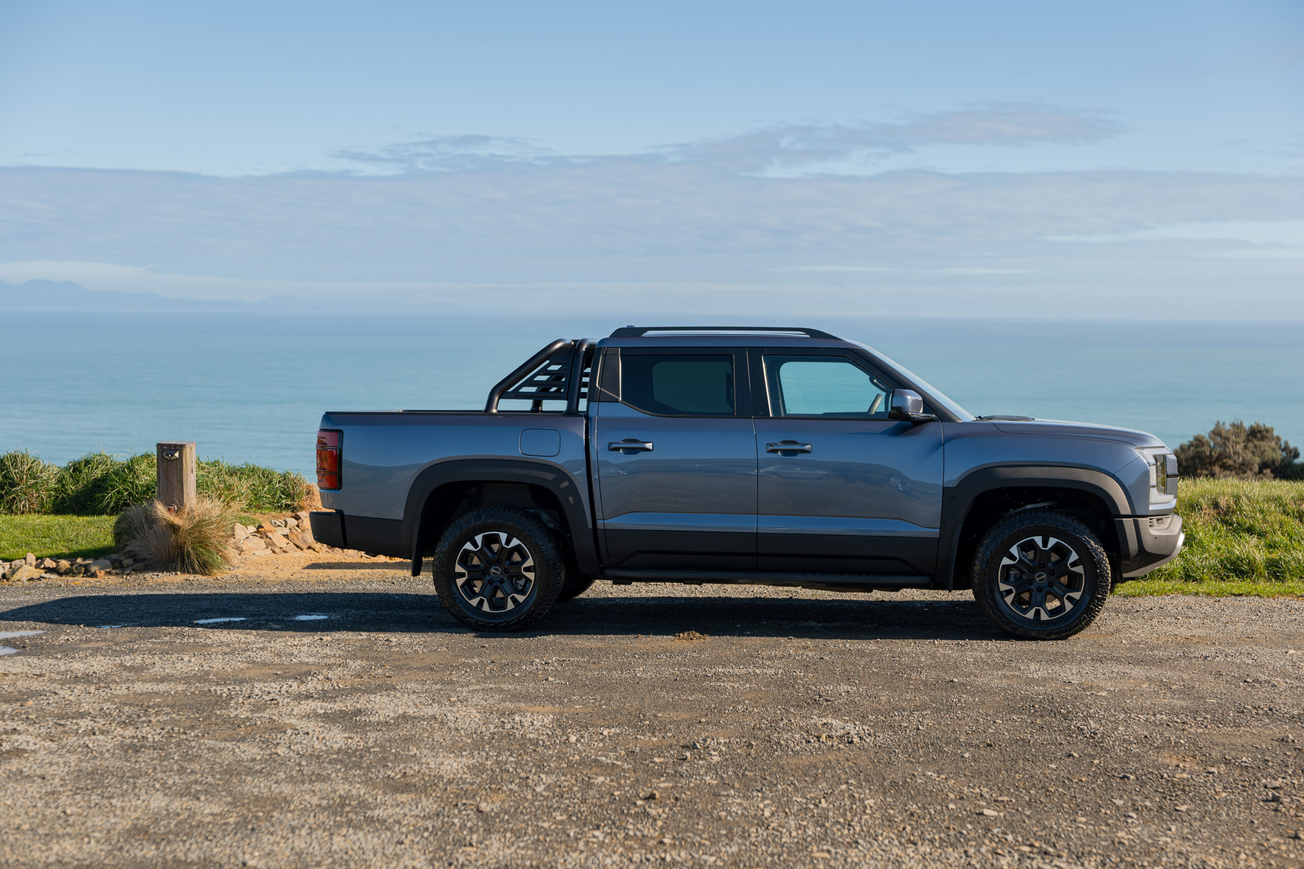 Blue BYD Shark 6 on farmland