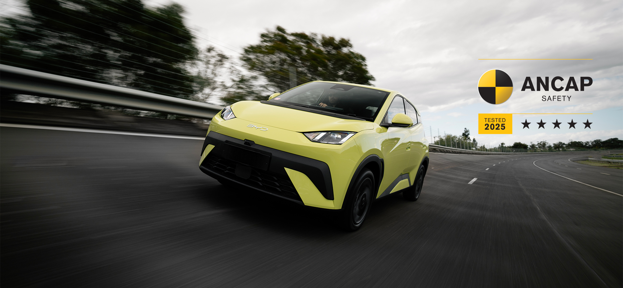 BYD ATTO 1 in Pine Lime driving around testing track with 5 star ANCAP Safety Rated logo