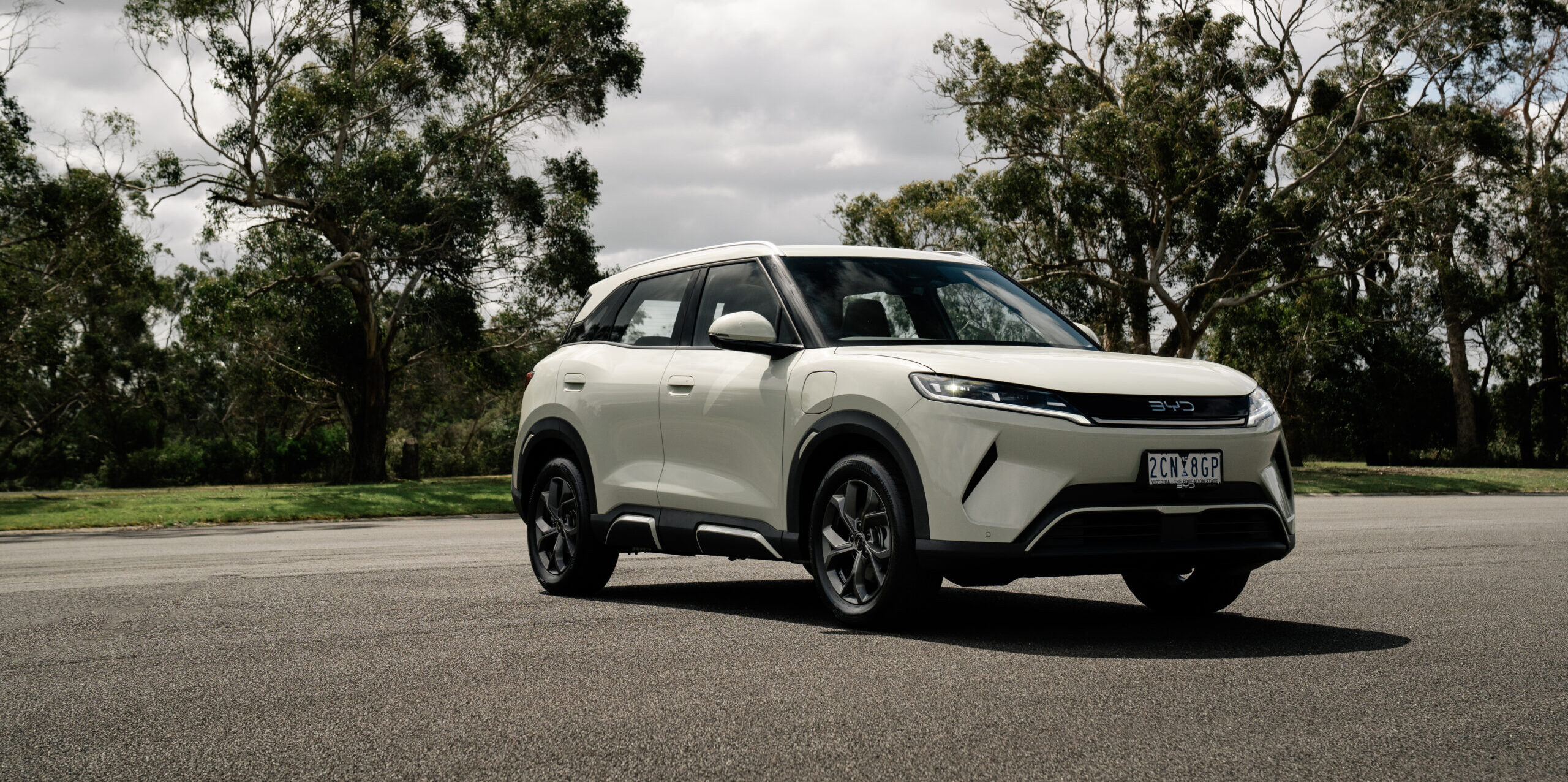 BYD ATTO 2 parked on road with trees behind