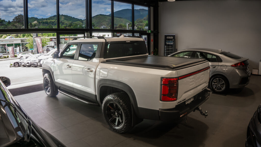 BYD Shark 6 White with Electric Sliding Tonneau Cover and Alloy Wheel Rims inside BYD Nelson Showroom