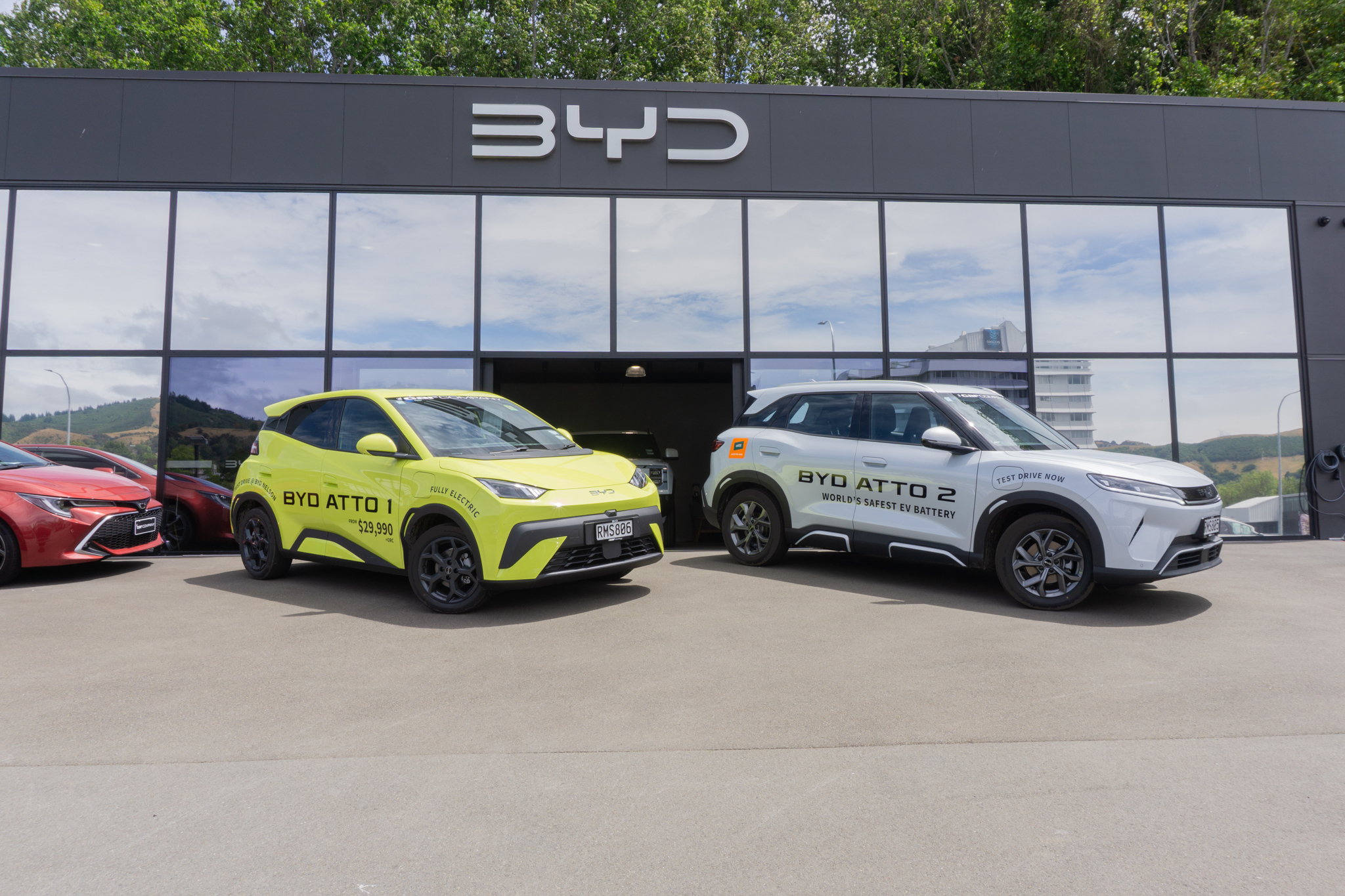 BYD ATTO 1 and ATTO 2 parked in front of the BYD Nelson showroom