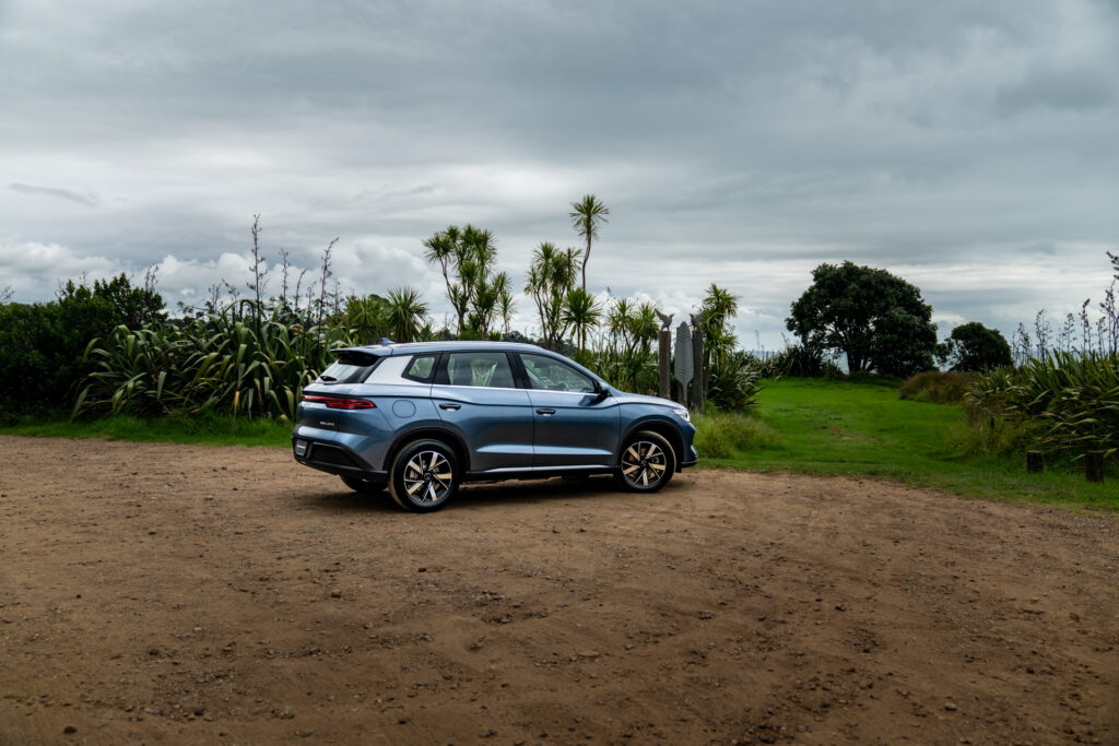 BYD Sealion 5 in blue, parked on dirt in front of NZ ocean