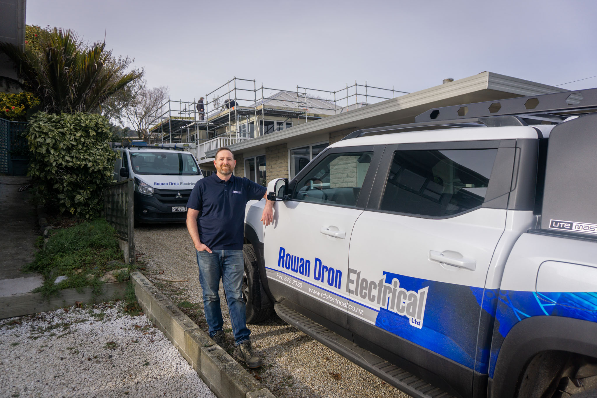 Rowan Dron Electrical owner, Rowan Dron, standing next to his BYD Shark 6 in Stoke, Nelson, New Zealand