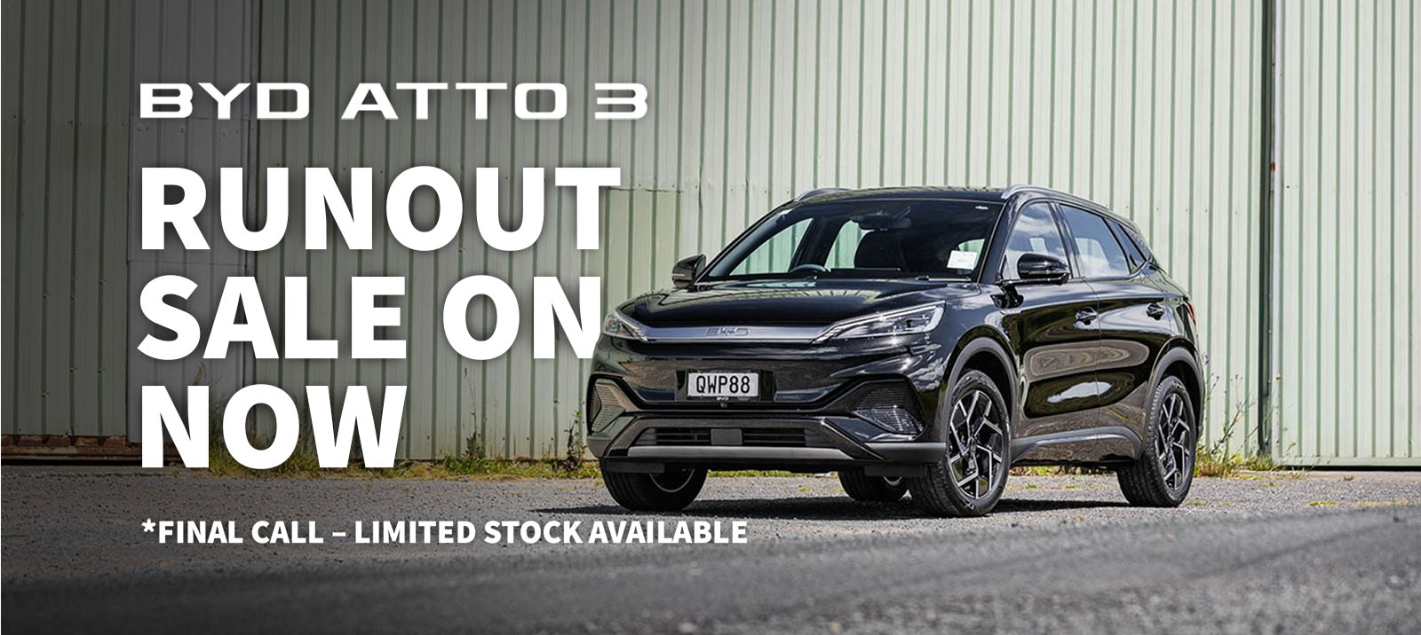 BYD Atto 3 runout sale text banner with black atto 3 parked by building
